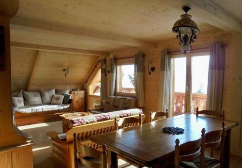 JarrierChalet Savoyard vue panoramique的一间带桌子和沙发的用餐室