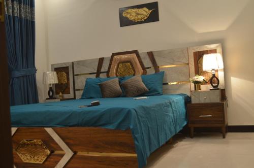 卡拉奇Dream home 2 & 4 bedroom Family house的一间卧室配有一张带蓝色床单和镜子的床