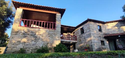 布拉加Casa das Oliveiras的一座大型石头建筑,上面设有阳台