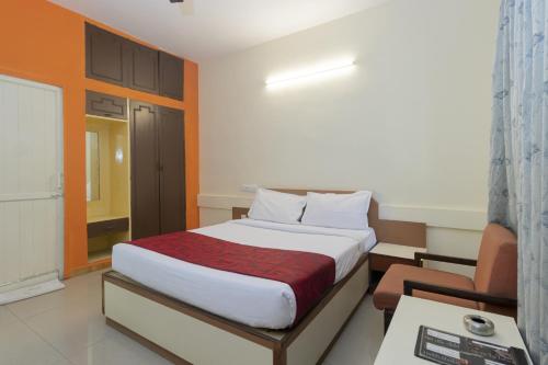 班加罗尔Hotel Telehaus International的一间卧室配有一张床、一张桌子和一把椅子
