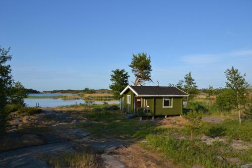 KökarKlobbars Gästhem o Stugor的湖畔的绿地中的一个小小屋