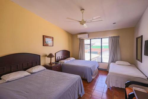 CañasHotel Caña Brava Inn的酒店客房设有两张床和窗户。