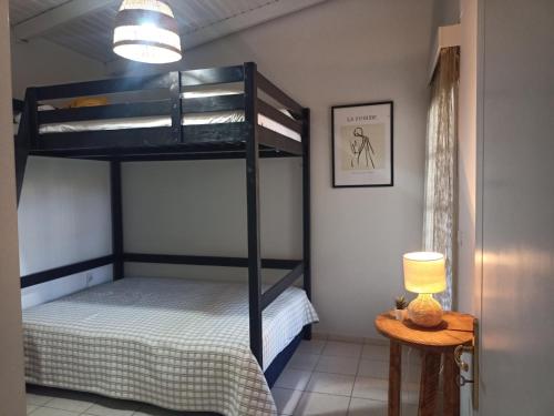 阿约伊阿波斯托洛伊A&V's Home的一间卧室配有一张双层床和一张带台灯的桌子