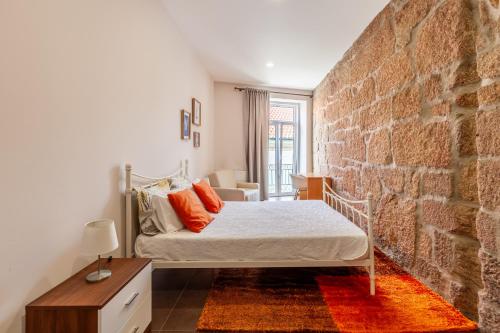 维拉·雷阿尔Porta 116的一间卧室设有一张床和砖墙