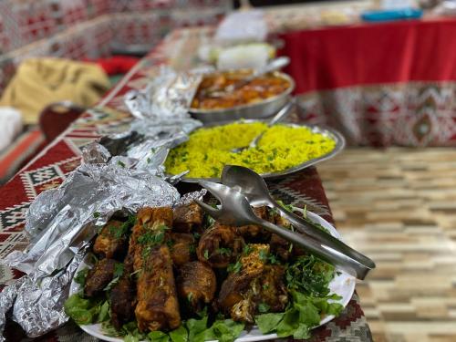 瓦迪拉姆Wadi Rum albasli的餐桌上放有肉和蔬菜的盘子