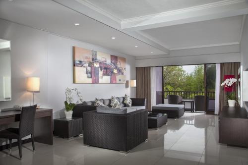 沙努尔巴厘岛沙努尔普莱姆广场套房酒店的客厅配有沙发和桌椅