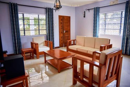 阿鲁沙Millance volunteer hosting and safaris的客厅配有沙发和桌子