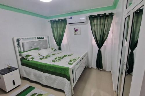 圣地亚哥洛斯卡巴Lujosa y espaciosa Villa María.的小卧室配有带绿色和白色床单的床