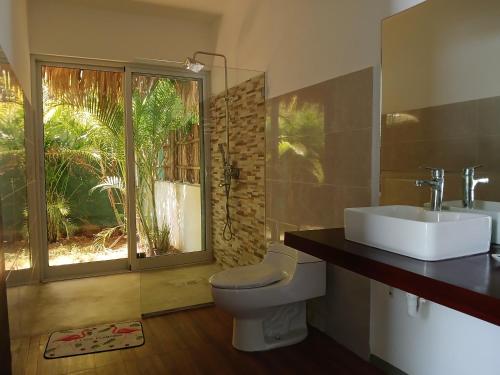 拉斯特拉纳斯Zodiaco in Las Terrenas的一间带卫生间、水槽和窗户的浴室