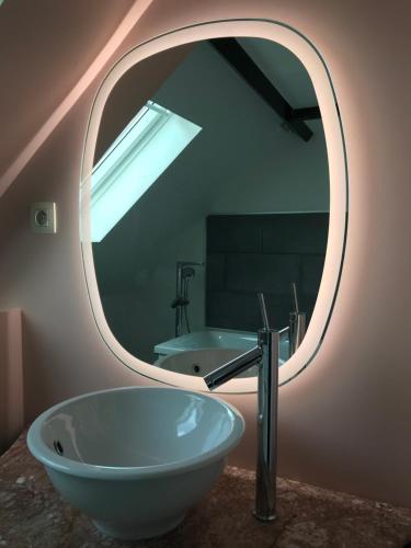 Comines圣乔治度假屋的一间带圆形镜子和水槽的浴室