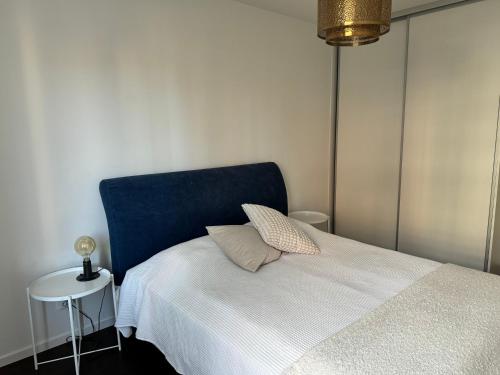 马尔默Tranquil and Convenience Southern Malmo Apartment的一间卧室配有一张带蓝色床头板的床和一张桌子