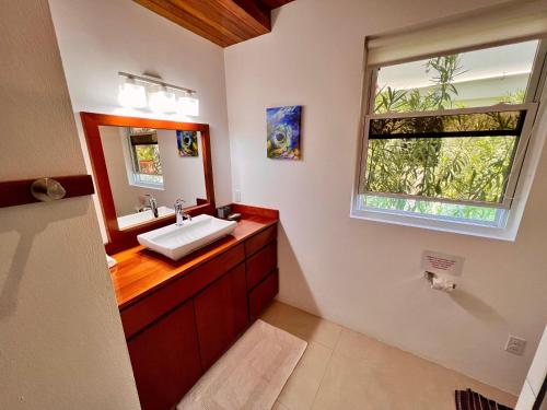 库尔克岛VeLento Partial Ocean View #6的一间带水槽和镜子的浴室以及窗户。