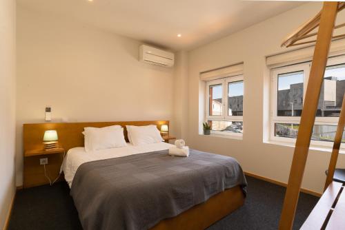 波尔图Peach Hostel & Suites的一间卧室设有一张大床和两个窗户