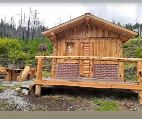 埃尔奥约Camping El Bosque的小屋设有门廊和长凳