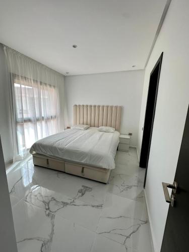 马拉喀什Appartement Prestigia 3 chambres的一间铺有大理石地板的卧室,配有一张床