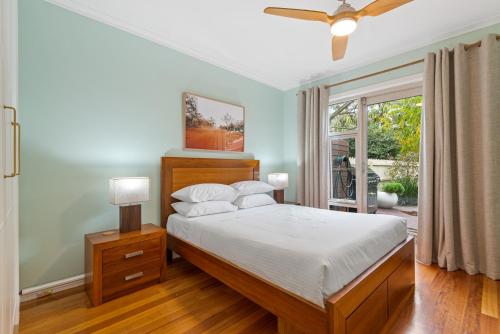墨尔本Perfect 2-Bed Inner-City Home with Pool & BBQ Area的一间卧室配有一张带白色床单的床和一扇窗户。