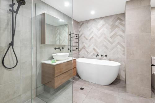 墨尔本Perfect 2-Bed Inner-City Home with Pool & BBQ Area的带浴缸、水槽和淋浴的浴室