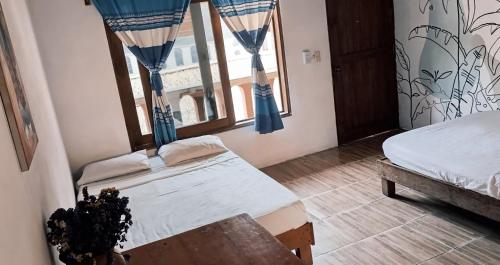 马祖特Casa H Rinconcito Mazunte的一间卧室设有两张床和窗户。