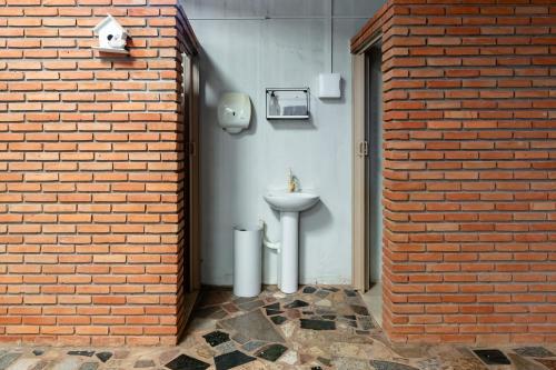 乌贝兰迪亚Quarto 04 Pousada Roosevelt的砖墙内带水槽的浴室