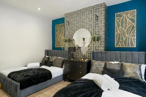 KentPlatinum Grove B Modern Flat, 2 Beds with Free Parking的卧室设有两张床,拥有蓝色的墙壁和镜子