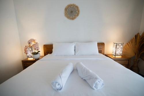 坎古Yolo 365 Villas and Resorts, Canggu, Bali的卧室配有白色床和毛巾