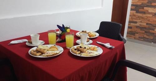 佩雷拉Hotel Coffee Real Pereira的餐桌,带食物盘和橙汁杯