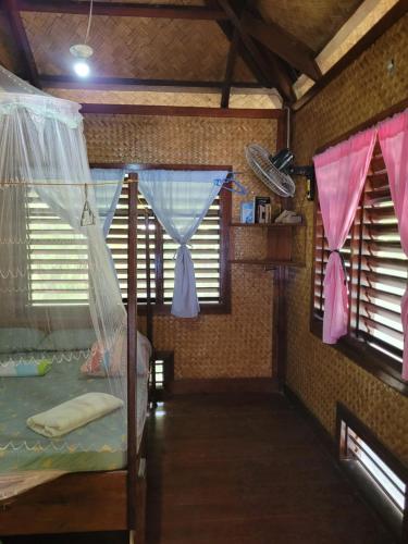 圣维森特MALAIKA RESORT的一间卧室设有2扇窗户和1张带蚊帐的床