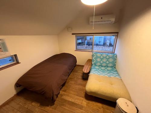 IchinomiyaB&BHOUSE FAM的小房间设有床和沙发