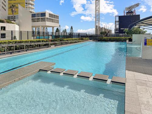 黄金海岸Oracle 11th floor Tower 1 - GC Getaways的大楼内带长椅的大型游泳池