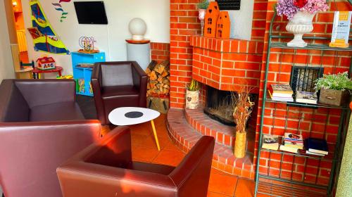 吕本瑙施普利瓦尔德贝斯特韦斯特酒店的客厅设有砖砌壁炉和椅子