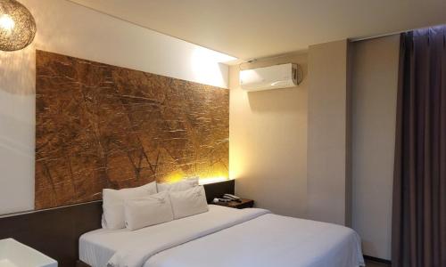 昌原市Jinhae Pasta Hotel的酒店客房设有一张床,墙上挂有绘画作品