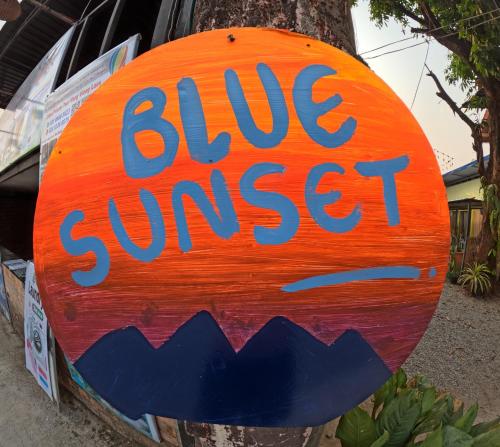 万荣Blue Sunset Hostel的读一棵树上蓝色日落的标志