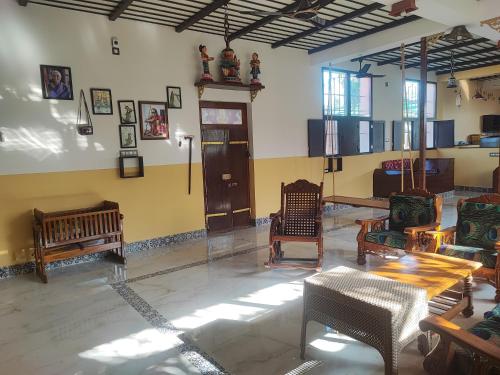 库姆巴科纳姆Maha Periyava Kuteeram的一间房间,配有桌椅