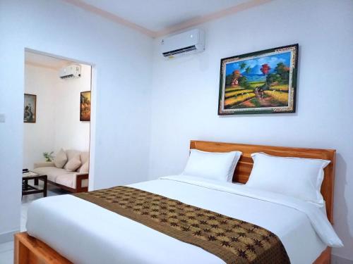 KrambitanRumah Bali Kelating的卧室配有一张白色的大床和一张沙发。