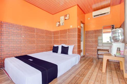 日惹Collection O 93742 Sidodadi Hotel Dan Resto的一间卧室设有一张床和砖墙