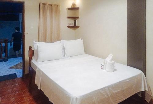 科隆RedDoorz at Amphibi-ko Resort Palawan的一张带白色床单和枕头的床