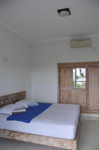 坎古The Hostel Canggu的一间卧室配有一张带木制床头板的床和窗户。