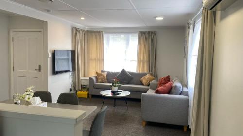 惠灵顿Comfy & Sunny home in Wellington的客厅配有沙发和桌子