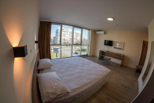 普罗夫迪夫HOTEL BAYKO的一间卧室设有一张床和一个大窗户