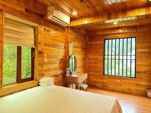 宁平Tam Coc Rocky Hotel的卧室设有木墙、一张床和窗户