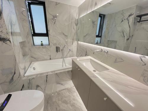 上海上海静安寺 阳光名都 豪华大三房公寓民宿 超大空间的浴室配有盥洗盆、卫生间和浴缸。