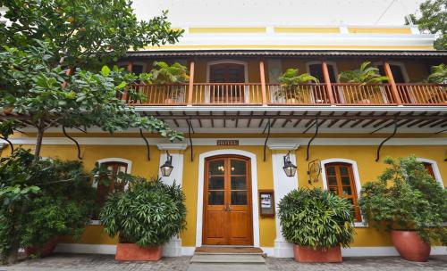 蓬蒂切里帕莱马埃酒店的黄色的房子,设有阳台和木门