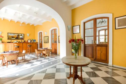 蓬蒂切里帕莱马埃酒店的客厅设有黄色的墙壁和鲜花桌