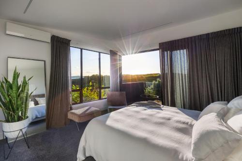 欧尼罗亚凯布尔海湾美景公寓的一间卧室设有一张大床和一个大窗户