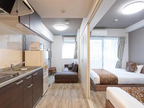 福冈Dream Inn Hakata的酒店客房设有一张床和一个带水槽的厨房