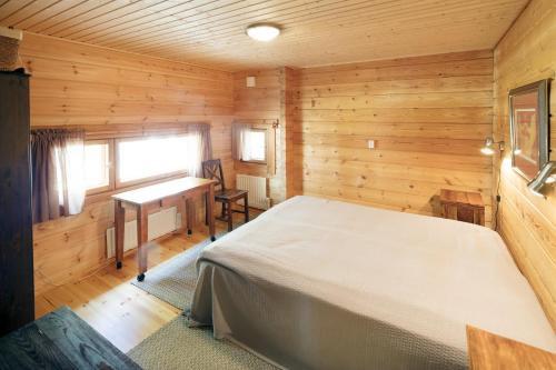 普马拉Okkolan Lomamökit的木制客房内的一间卧室,配有一张床