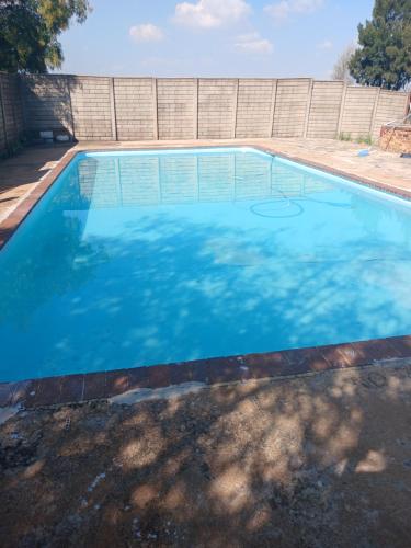 BrakpanKharimbi Campsite House的蓝色海水大型游泳池