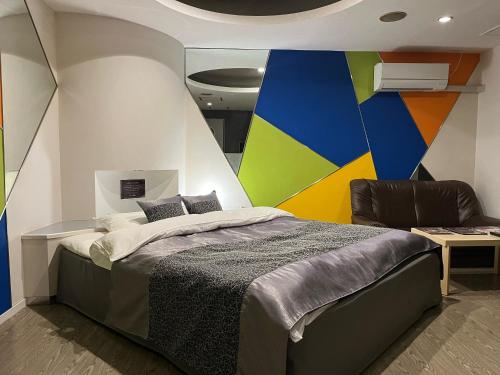 蟹江HOTELウォーターゲート蟹江（カップル専用）的一间卧室配有一张带彩色墙壁的床