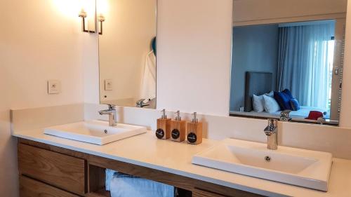 格兰高伯Paradise Villa的一间带两个盥洗盆和大镜子的浴室