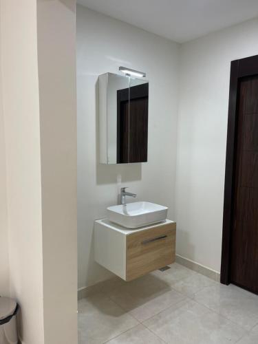 吉布提WAAFI CITY CENTER RESIDENCE的白色的浴室设有水槽和镜子